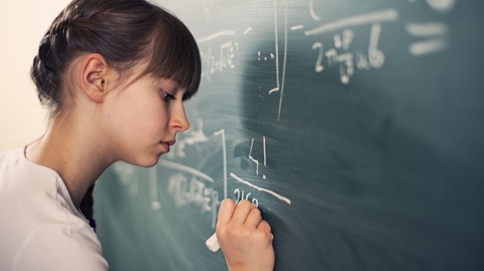 Little girl writing difficult mathematics equations Little girl writing difficult mathematics equations